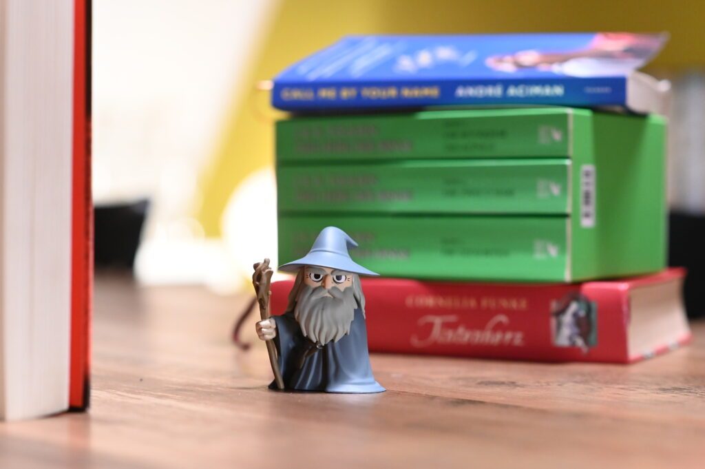 Eine Gandalf-Figur steht vor einem Stapel Bücher.